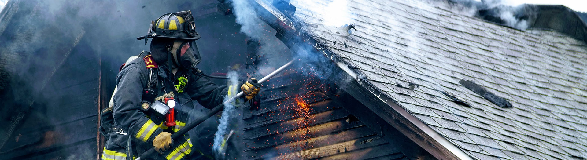 fire fighter working on roof with embers