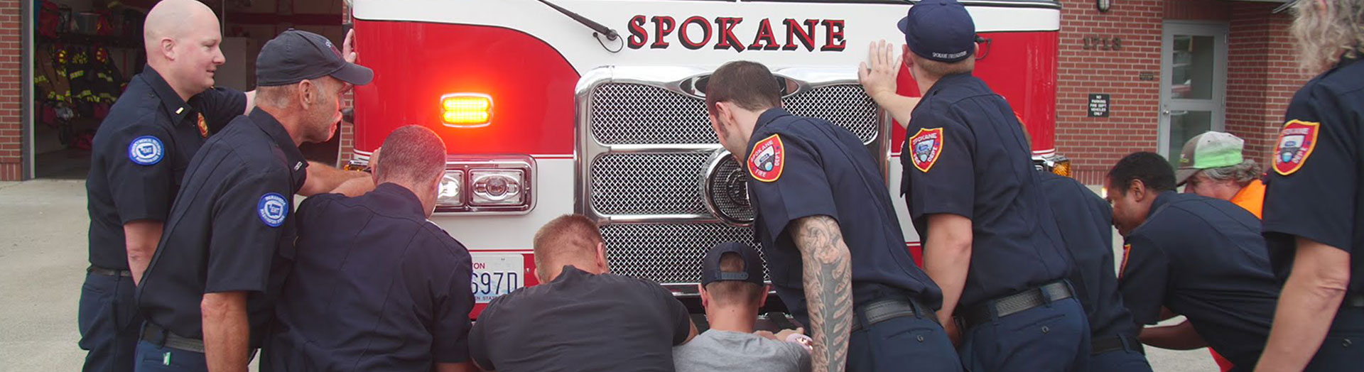 Spokane Fire Fighters "push in" around the front of their fire truck